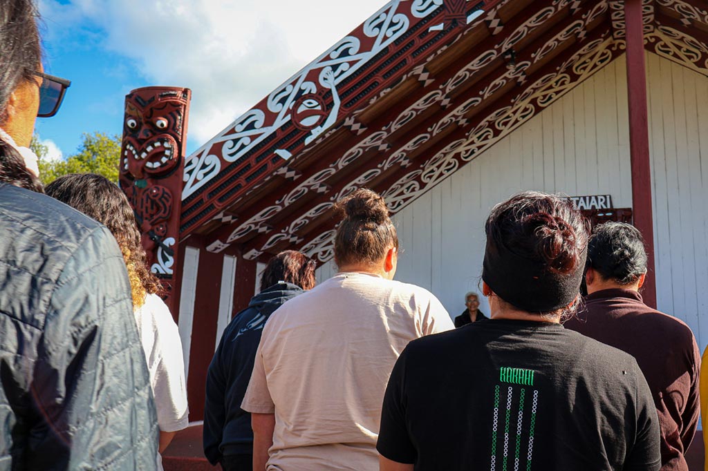A group of people entering the wharenui